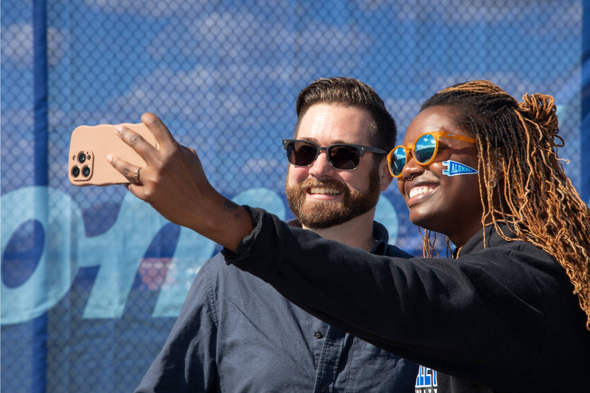 Two alumni take a selfie at the Homecoming tailgate